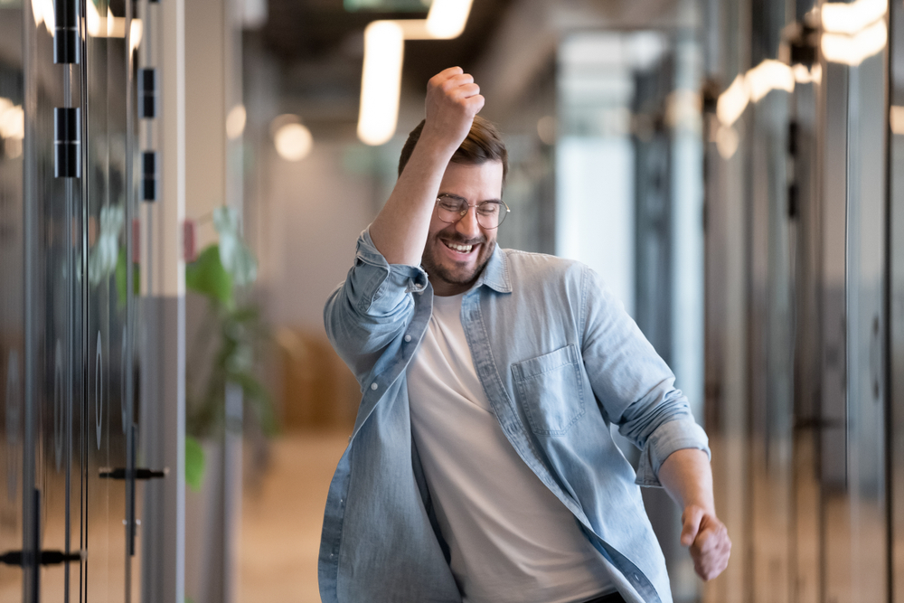 Ecstatic,excited,male,winner,dancing,in,office,hallway,laughing,celebrating